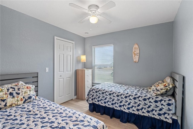 bedroom featuring ceiling fan, a closet, and light hardwood / wood-style floors