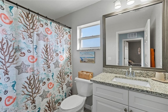 bathroom featuring walk in shower, vanity, and toilet