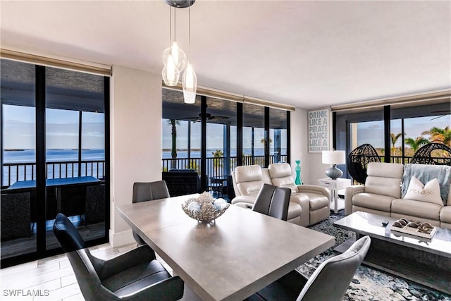 dining space with a water view, a wall of windows, and a wealth of natural light