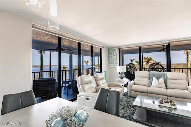 living room with a water view, a wall of windows, and hardwood / wood-style flooring