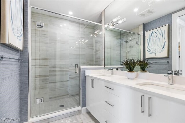 bathroom featuring a shower with door and vanity