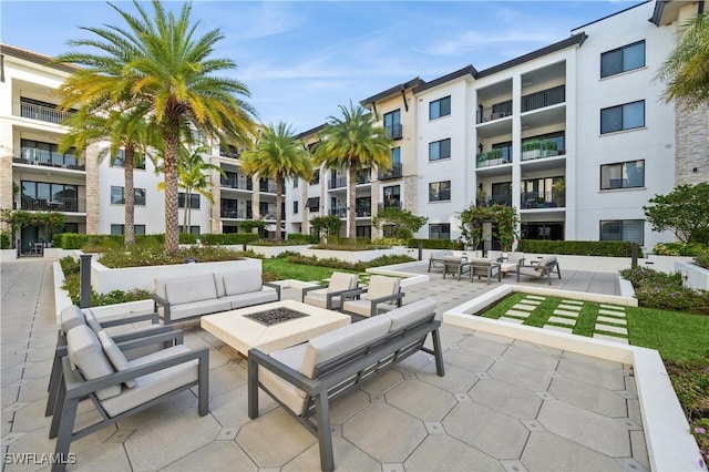 view of community featuring a patio area and an outdoor living space with a fire pit