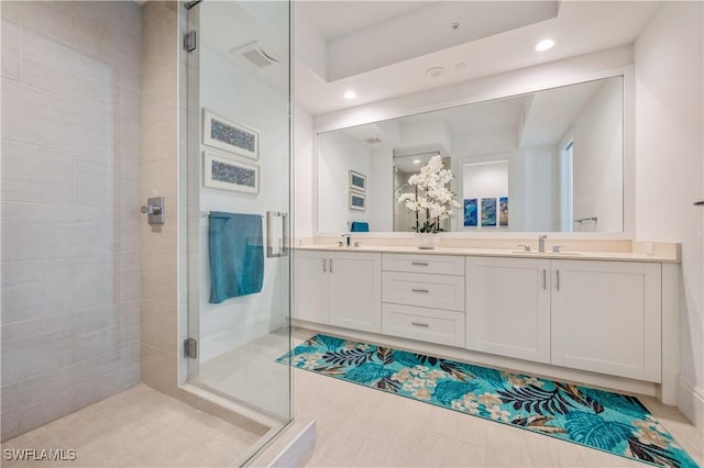 bathroom with vanity and a shower with door