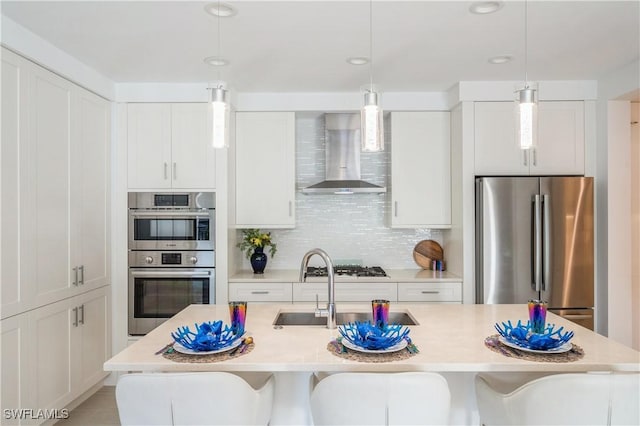 kitchen featuring backsplash, white cabinets, wall chimney exhaust hood, and stainless steel appliances