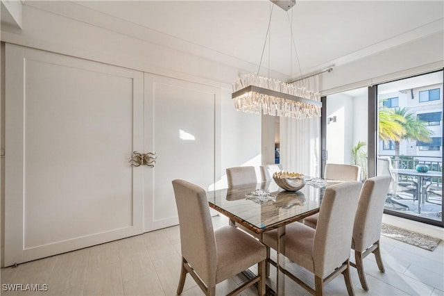 dining space with an inviting chandelier and ornamental molding