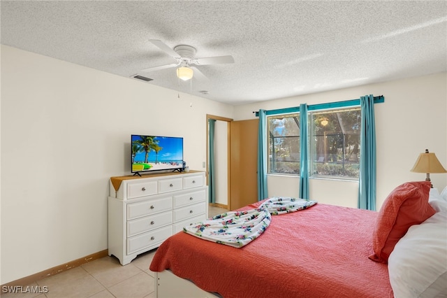 tiled bedroom with a textured ceiling and ceiling fan