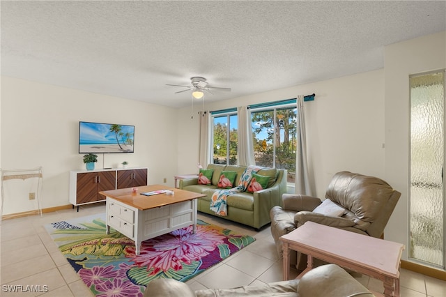 living room featuring ceiling fan, light tile patterned flooring, and a textured ceiling