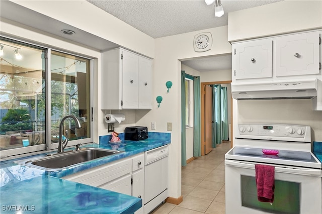 kitchen featuring a textured ceiling, white appliances, sink, light tile patterned floors, and white cabinets