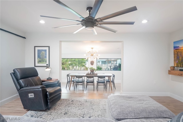 interior space featuring light hardwood / wood-style flooring and ceiling fan with notable chandelier