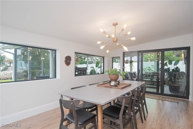 dining area with plenty of natural light, a chandelier, and light wood-type flooring