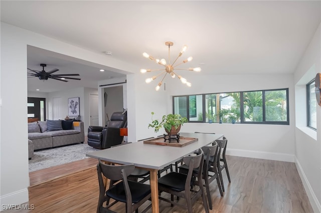 dining room featuring ceiling fan with notable chandelier and light wood-type flooring