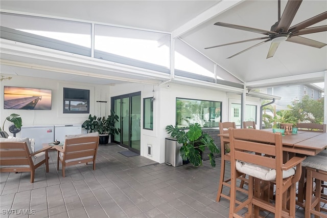 sunroom / solarium featuring vaulted ceiling with beams and ceiling fan