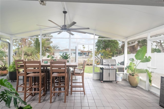 sunroom featuring vaulted ceiling and ceiling fan