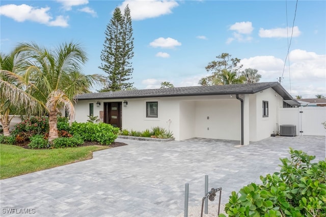 single story home with central AC unit and a garage