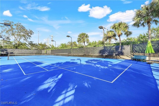 view of tennis court featuring basketball hoop