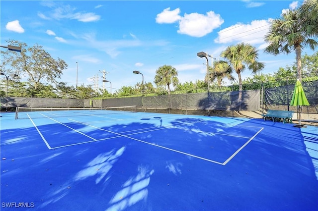 view of tennis court featuring fence