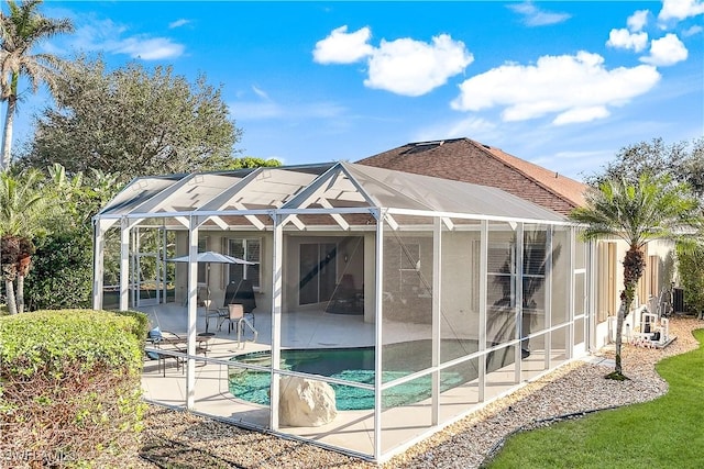 rear view of property featuring a patio and a lanai