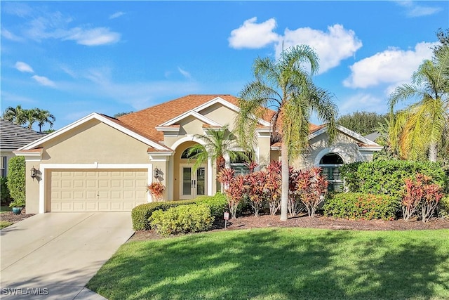 view of front facade featuring a garage, driveway, a front lawn, and stucco siding