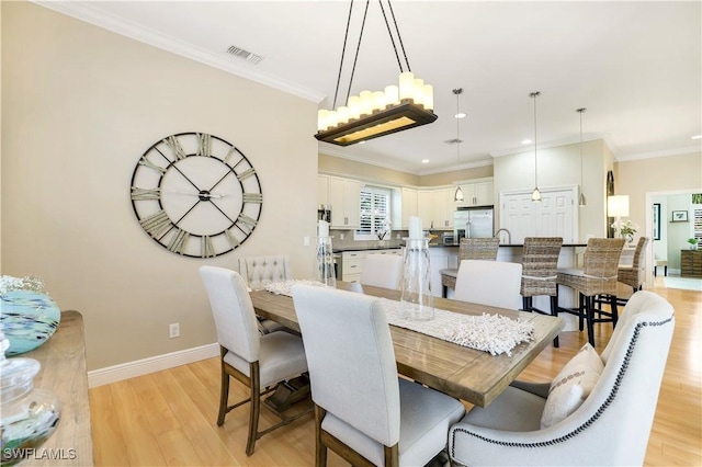 dining space featuring light wood-style flooring, ornamental molding, visible vents, recessed lighting, and baseboards