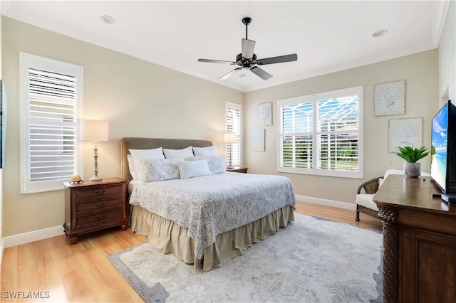 bedroom featuring ornamental molding, light wood-style flooring, ceiling fan, and baseboards