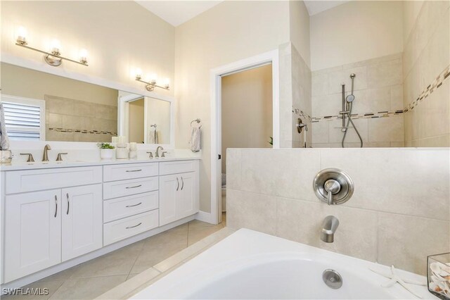 full bath with tile patterned floors, double vanity, a sink, and walk in shower