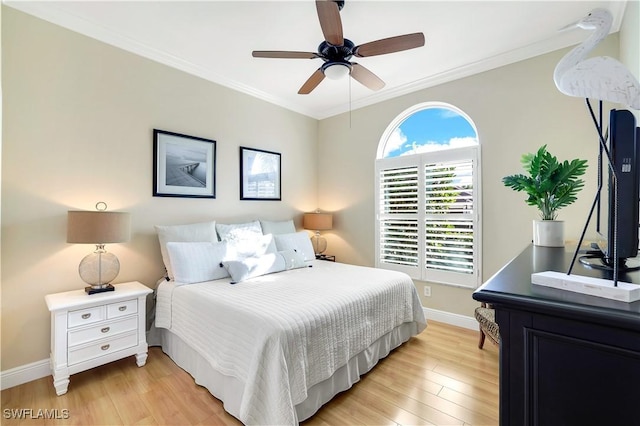 bedroom with ornamental molding, light wood-style floors, and baseboards