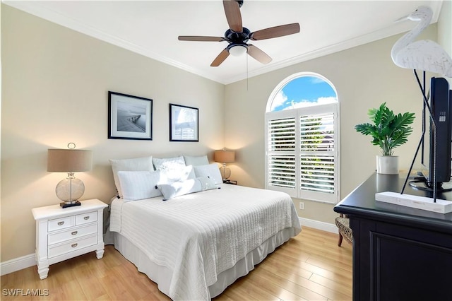 bedroom with light wood-style flooring, baseboards, crown molding, and a ceiling fan