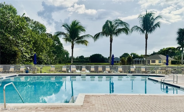 pool with fence and a patio