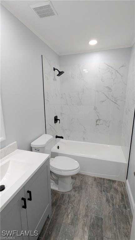 full bathroom with crown molding, toilet, vanity, and tiled shower / bath