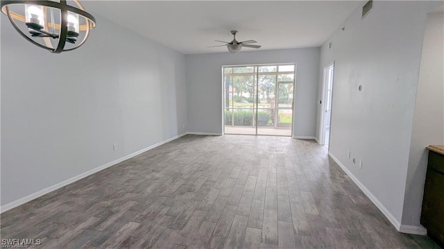 interior space featuring ceiling fan with notable chandelier and dark wood-type flooring