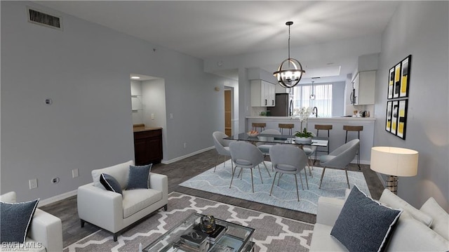 dining area with hardwood / wood-style floors and an inviting chandelier