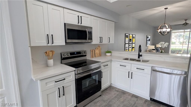 kitchen featuring white cabinets, sink, kitchen peninsula, and stainless steel appliances