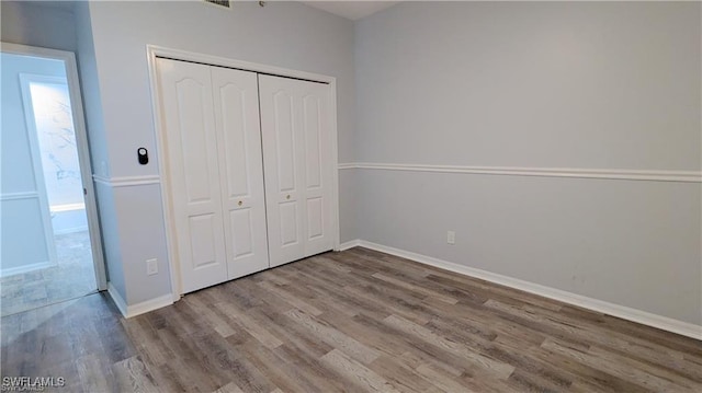 unfurnished bedroom featuring hardwood / wood-style flooring and a closet