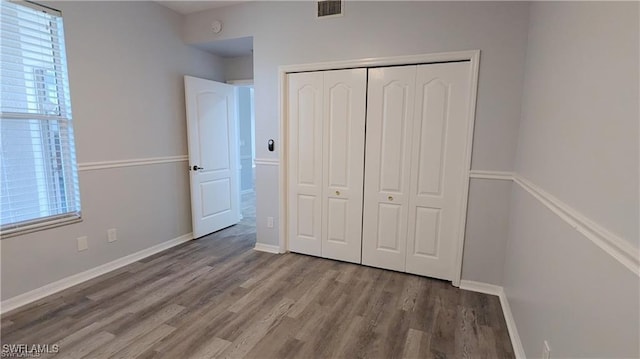 unfurnished bedroom featuring wood-type flooring and a closet