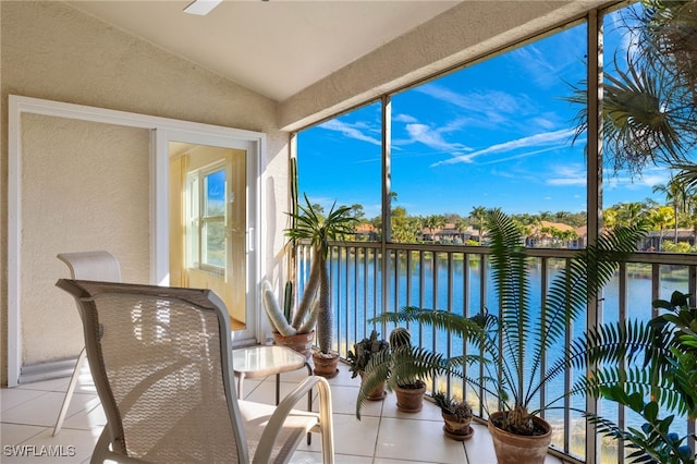 sunroom with a water view and vaulted ceiling