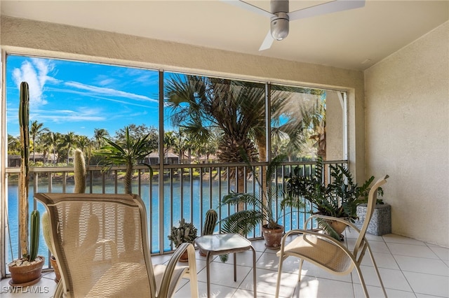 sunroom / solarium featuring ceiling fan and a water view