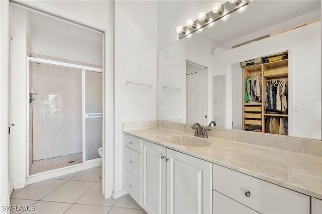 bathroom with tile patterned floors, vanity, toilet, and an enclosed shower