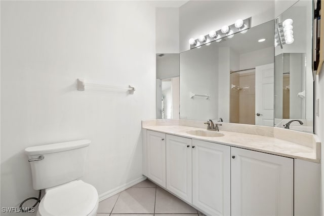 bathroom with tile patterned flooring, vanity, toilet, and a tile shower