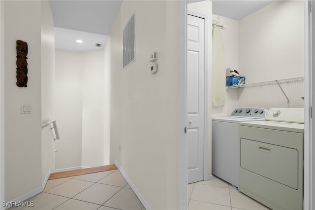 laundry area featuring light tile patterned flooring and washing machine and dryer