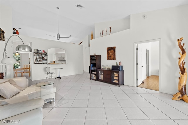 tiled living room featuring ceiling fan and vaulted ceiling