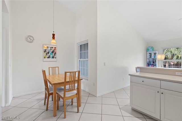 tiled dining space featuring high vaulted ceiling