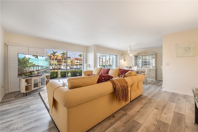 living room with ceiling fan and light hardwood / wood-style flooring