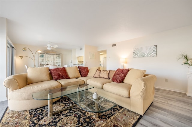 living room with ceiling fan and light hardwood / wood-style flooring