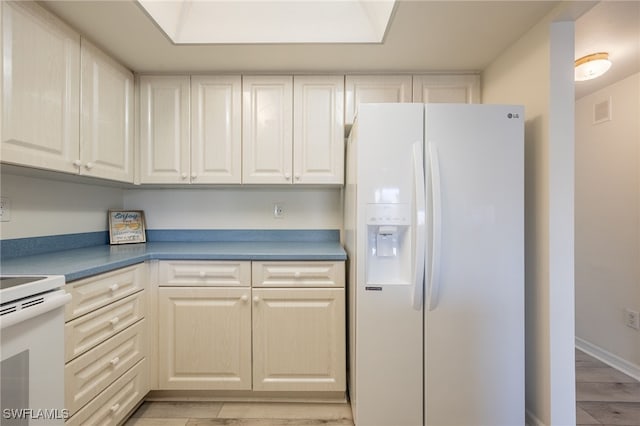 kitchen featuring light hardwood / wood-style floors and white appliances