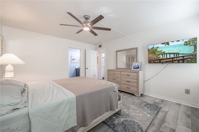 bedroom with ceiling fan, light hardwood / wood-style floors, and ensuite bathroom