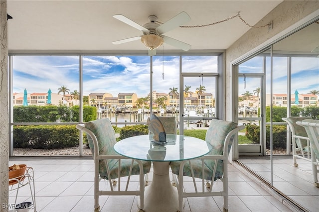 sunroom featuring a water view and ceiling fan