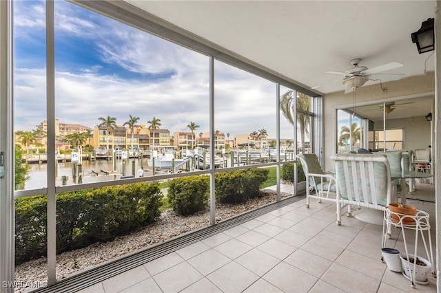 unfurnished sunroom with a water view and ceiling fan