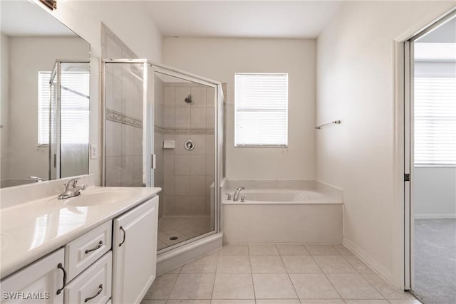 bathroom featuring tile patterned floors, vanity, and shower with separate bathtub