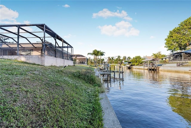 dock area with a lanai and a water view