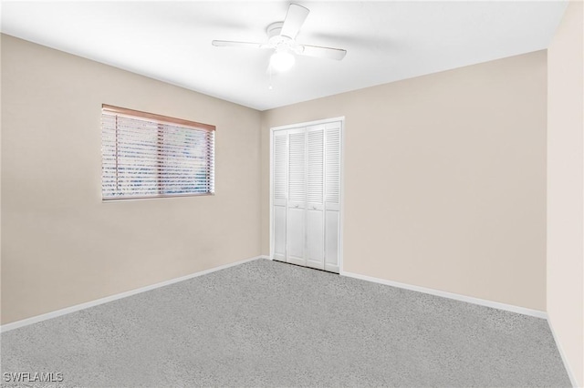 unfurnished bedroom featuring ceiling fan, a closet, and carpet